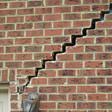 stair step cracking reaching from a window along the foundation wall in Spartanburg