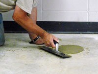 Repairing the cored holes in the concrete slab floor with fresh concrete and cleaning up the Easley home.