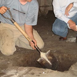 Digging a hole for the engineered fill used in a crawl space support system installation in Greer