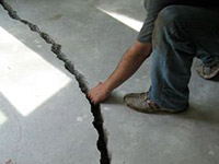 a severely damaged cracked concrete slab floor in Candler