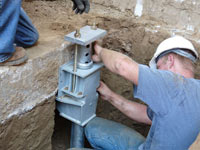 Foundation repair contractors installing the foundation bracket in Spartanburg.