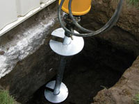 Installing a helical pier system in the earth around a foundation in Columbia