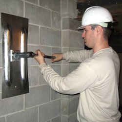 installing a wall anchor to repair an bowing foundation wall in Greenwood