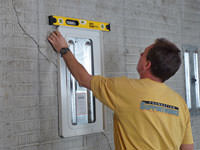 Positioning a wall plate cover on a foundation wall in Greer.