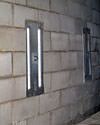 an inside view of foundation wall anchors installed along a basement wall to brace and repair the structure in Seneca