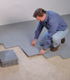 Contractors installing basement subfloor tiles and matting on a concrete basement floor in Lexington, North Carolina, South Carolina & Georgia